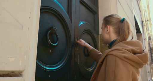 Woman coming up to house and opening front door
