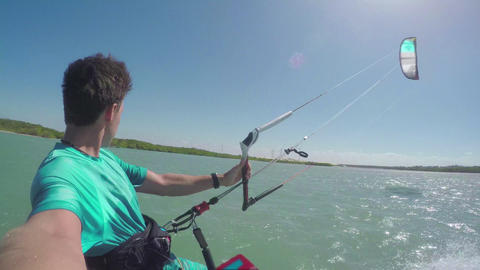 Kiter kiteboarding in sunny flat lagoon