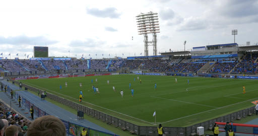 Football match before crowded stands at the stadium
