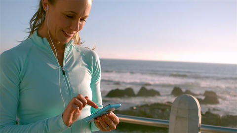 Smiling sporty woman on her smartphone