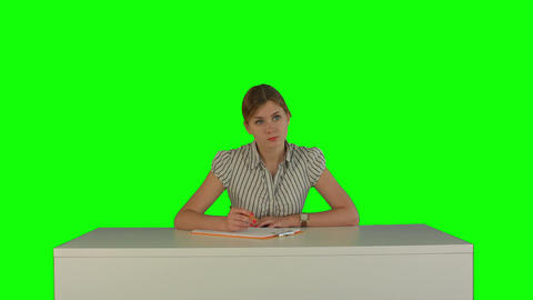 Young girl sitting in classroom at lecture and listening teacher on a Green Scre