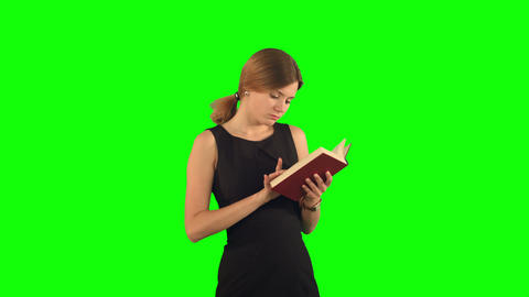 Young girl with book on laptop on a Green Screen, Chroma Key