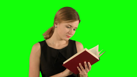 Young beautiful girl reading a book on laptop on a Green Screen, Chroma Key
