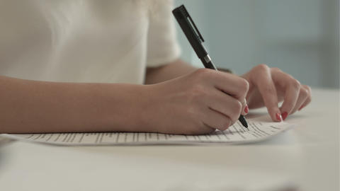 Businesswoman writes on a document at her office