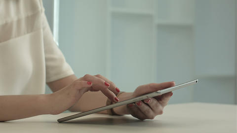 Woman sitting in office table and touch tablet