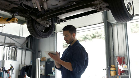 Handsome mechanic overhauling a car